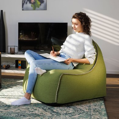 Eine Frau sitzt im Wohnzimmer und malt