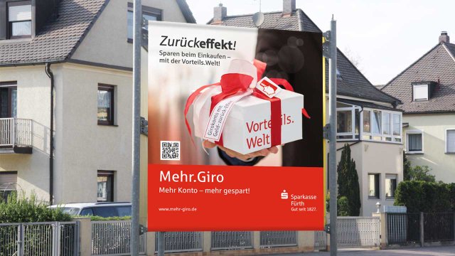 Werbebanner des MehrGiro Konzepts von der Sparkasse Fürth. Ein weißes Geschenk mit rotem Band wird präsentiert.