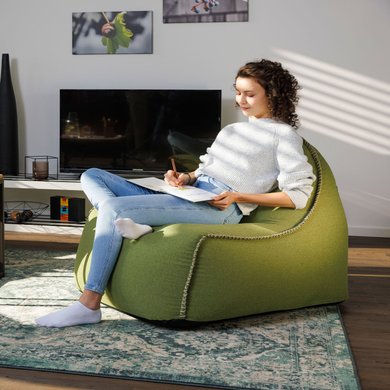 Eine Frau sitzt im Wohnzimmer und malt