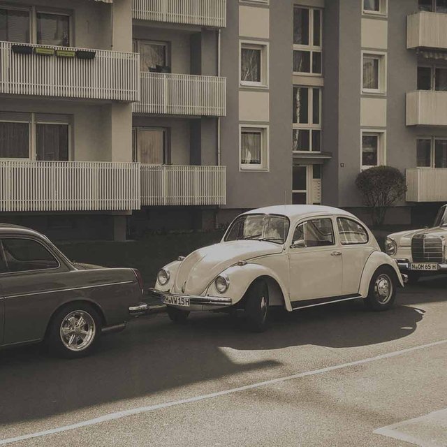 70er Jahre Autos parken vor Mehrfamilien-Häusern