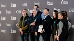 Das ganze Team von da kapo vor der Gewinnerwand der German Design Awards posiert für ein Foto