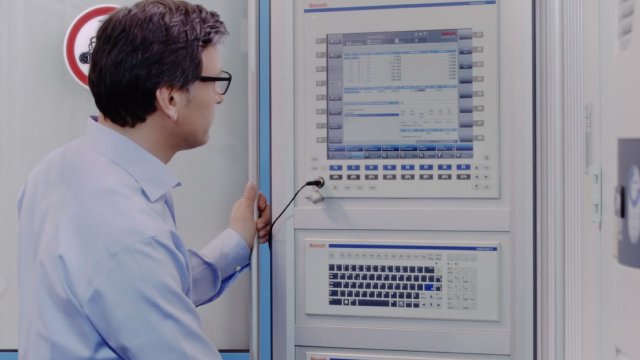 Ein Mitarbeiter schaut auf ein Display von Bosch Rexroth. 