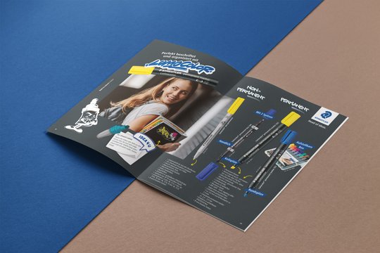 Aufgeschlagene Seite vom Back to School Katalog zeigt verschiedene Lumocolor Stifte