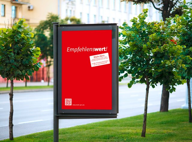 Ein Poster in einer Reklametafel. Die Sparkasse Fürth bewirbt mit einer roten Fläche und dem Slogan Empfehlenswert ihr Mehr Giro Konzept