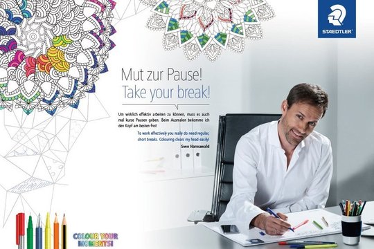 Sven Hannawald sitzt an seinem Schreibtisch und malt Mandala