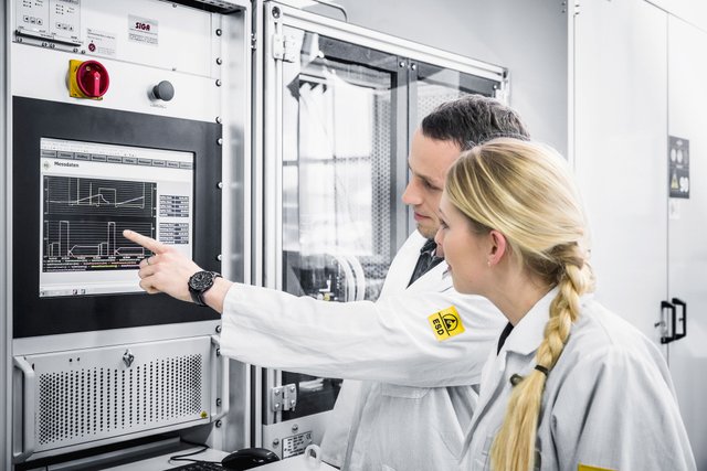 Zwei Mitarbeitende von k3 works schauen sich eine Schaltfläche einer Maschine an