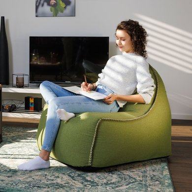 Eine Frau sitzt im Wohnzimmer und malt