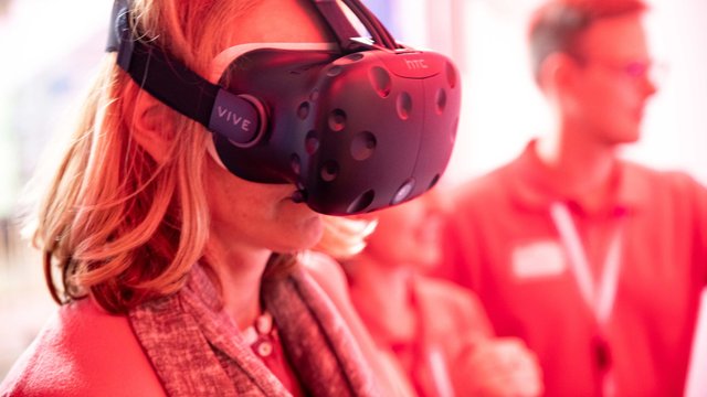Besuchende auf der Langen Nacht der Wissenschaft am Ergo Stand mit einer VR-Brille.