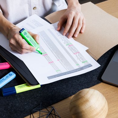 Arbeitsblätter werden mit einem Marker von Staedtler markiert.