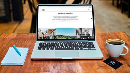Webseite und Visitenkarte da kapo Projekt: Branding & Awareness Concept Kunde Neue Höfe Schreibtisch mit Laptop und Webseite Neue Höfe, sowie Visitenkarte am Tisch