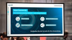 Blick auf einen Monitor auf der Messe. Auf diesem sind Infos zum Smart Funktion Kit von Bosch Rexroth zu lesen.