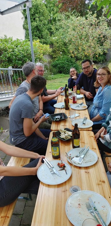 Mitarbeiter beim Essen, Biergarnitur im Garten, gesellige Runde, da kapo Teamevent, Abschied von der alten Agentur