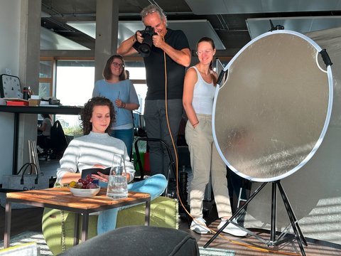 Das Model, der Fotograf und die Visagistin bei der Arbeit beim Fotoshooting